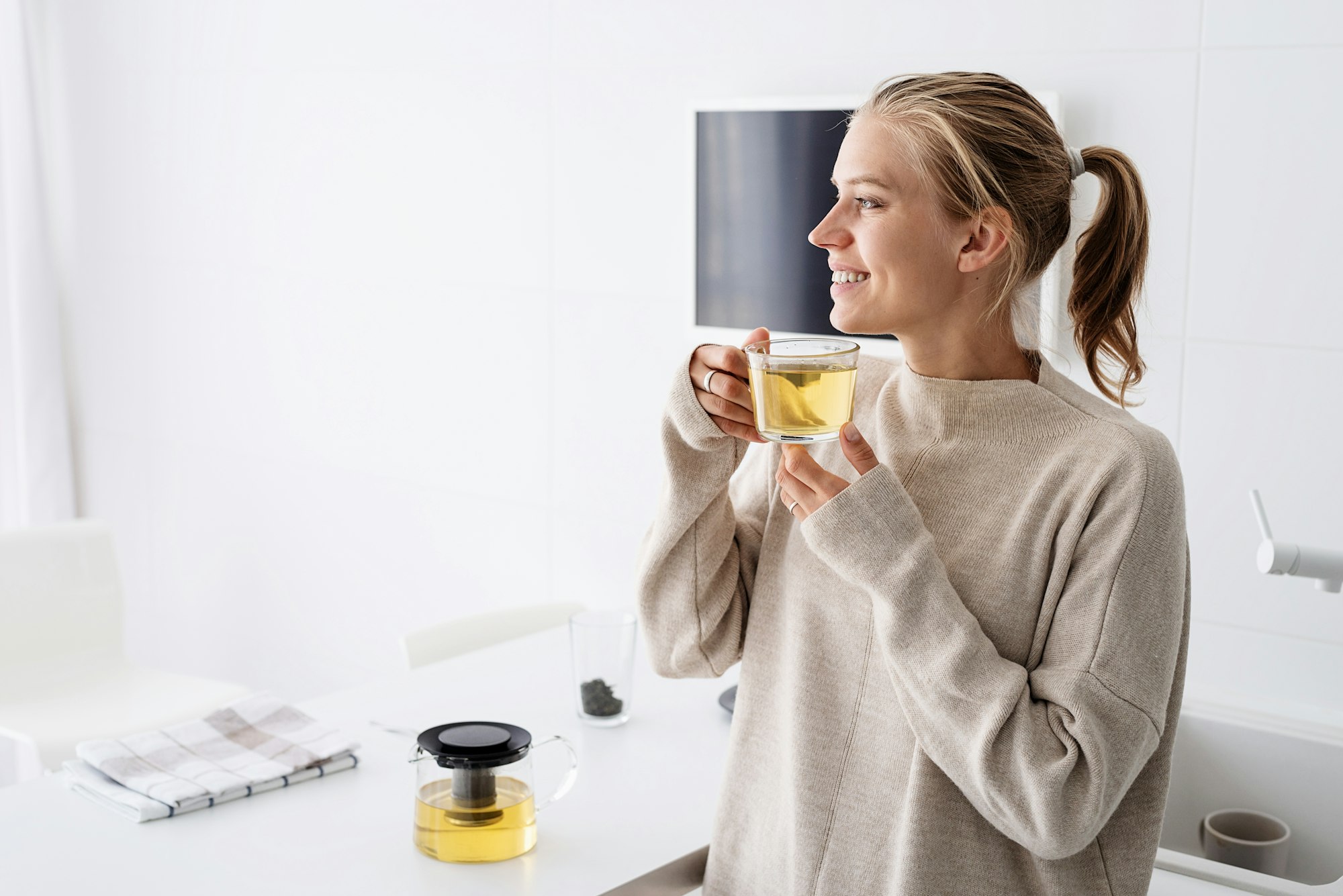 Attractive woman drinking tea at home kitchen